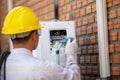 The air conditioner technician checks the electrical power of the air conditioner compressor from the outside