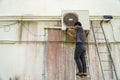 Air conditioner technician is installing the air conditioner on the wall of the house Royalty Free Stock Photo