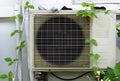 Air conditioner on the wall with green leaves in the garden on top have a socks are drying Royalty Free Stock Photo