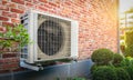 Air conditioning heat pump outdoor unit against brick wall. Royalty Free Stock Photo