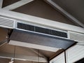 Air conditioning wall mounted ventilation system on ceiling in the white hotel room.