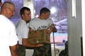 Air Force personnel carry bottled water into church for Hurricane Katrina victims.