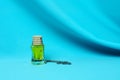 Air fragrance. A glass bottle with a yellow liquid, a wooden stopper on a wavy blue background Royalty Free Stock Photo