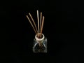 Air freshener on a black background. Incense sticks in a container with perfume. Aromatherapy canes in a glass bottle with oil Royalty Free Stock Photo