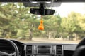 Air freshener hanging on rear view mirror in car