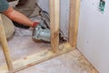 An air hammer is being used builder to nail wooden beams to housing a frameworks