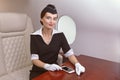 Air hostess sits by window inside airplane Royalty Free Stock Photo