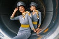 Air hostesses in pilot caps sitting in the turbofan engine