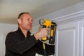 Air Nailer Tool, Carpenter using nail gun to crown moldings on kitchen cabinets