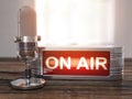 On the air. Old microphone with vintage signboard On air on the wooden table. Broadcasting radio station concept