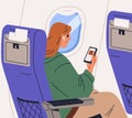 Air passenger listening to music in earphones during flight. Woman tourist sitting in airplane seat with mobile phone