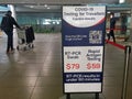 Air passengers passing by COVID -19 PCR swab test sign in Brisbane Airport Queensland Australia