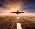 Air plane flying over airport runway with city scape and sunset sky background Royalty Free Stock Photo