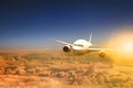 Air plane flying over cloud scape and sun light behind Royalty Free Stock Photo