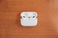 Air Pods Pro. with Wireless Charging Case. New Airpods pro on wooden background. Airpods. Copy space