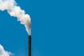 Air pollution from factory. Smoke from chimney of industrial pipe on clear blue sky. Greenhouse effect and global warming problem Royalty Free Stock Photo