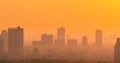 Air pollution. Smog and fine dust of pm2.5 covered city in the morning with orange sunrise sky. Cityscape with polluted air. Dirty