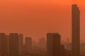 Air pollution. Smog and fine dust of pm2.5 covered city in the morning with red sunrise sky. Cityscape with polluted air. Dirty