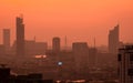 Air pollution. Smog and fine dust of pm2.5 covered city in the morning with red sunrise sky. Cityscape with polluted air. Dirty