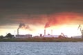 Air pollution by smoke coming out of two factory chimneys. Industrial zone in the city Royalty Free Stock Photo