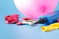 Air-pump inflating a pink ballon on a blue background Royalty Free Stock Photo