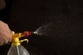 Air pump water spray bottle. close up of a spraying water drops isolated on black background Royalty Free Stock Photo