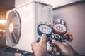 Air repair mechanic using measuring pressure gauge equipment for filling home air conditioner Royalty Free Stock Photo
