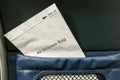 Air sickness bag tucked behind airplane seat pocket