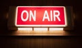 On Air sign icon glowing on the wooden wall of sound recording studios, live broadcast radio production room Royalty Free Stock Photo