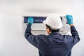 Air technician service checking and repairing air conditioner on white wall. Service concept of an air conditioner technician Royalty Free Stock Photo