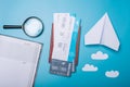 Air tickets with passport and paper plane on blue background, topview. The concept of air travel and holidays