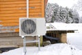 Air to water heat pump near an old wooden house in winter. air water heatpump close up