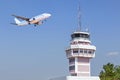 Air traffic control tower in international airport with passenger airplane jet taking off Royalty Free Stock Photo