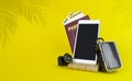 Air travelling concept, passport, boarding pass, suitcases and smartfone on yellow background