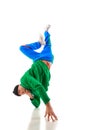 Air twist. Young athletic man, b-boy dancing hip-hop, breakdance on hands raising legs up in motion against white Royalty Free Stock Photo