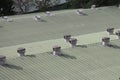 Air ventilators that are not driven by power on the roof of some small industry. Ventilators on roof top that spins and takes wind