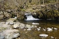 Aira Beck cascades over a small waterfall into a shallow pool