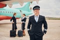 Aircraft crew in work uniform is together outdoors near plane Royalty Free Stock Photo