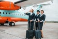 Aircraft crew in work uniform is together outdoors near plane Royalty Free Stock Photo