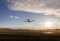 An aircraft on final at YVR with the sunset in the background.