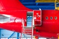 The aircraft in the hangar to check technical systems auxiliary power unit. Tail view and rear fuselage open door with stairs and Royalty Free Stock Photo