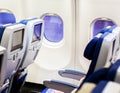 Aircraft interior with seats and blank touch screens displays. Royalty Free Stock Photo