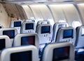 Aircraft interior with seats and blank touch screens displays. Royalty Free Stock Photo