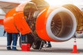 Aircraft Maintenance Mechanics Inspecting and Working on Airplane Jet Engine on Apron. Royalty Free Stock Photo