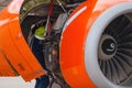 Aircraft Maintenance Mechanics Inspecting and Working on Airplane Jet Engine on Apron.