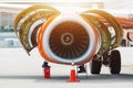 Aircraft Maintenance Mechanics Inspecting and Working on Airplane Jet Engine on Apron. Royalty Free Stock Photo