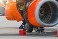 Aircraft Maintenance Mechanics Inspecting and Working on Airplane Jet Engine on Apron. Royalty Free Stock Photo