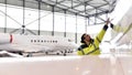 Aircraft mechanic inspects and checks the technology of a jet in a hangar at the airport Royalty Free Stock Photo