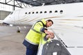 Aircraft mechanic inspects and checks the technology of a jet in Royalty Free Stock Photo