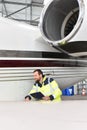 Aircraft mechanic inspects and checks the technology of a jet in a hangar at the airport Royalty Free Stock Photo